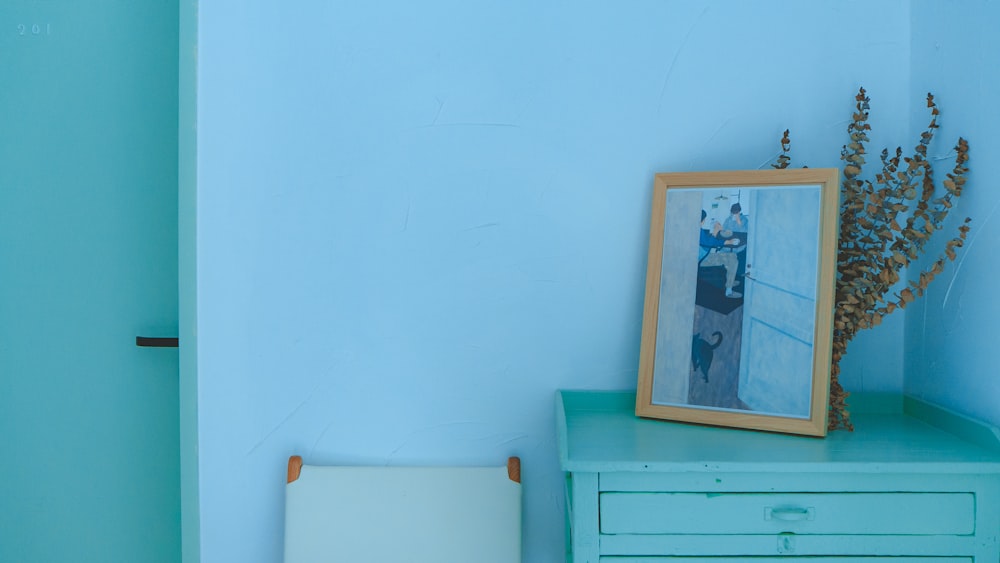 brown photo frame on teal table near door