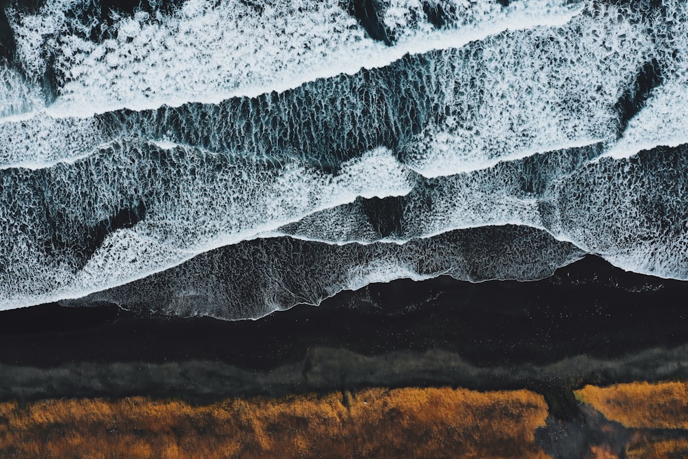 Eine Luftaufnahme eines Strandes mit Wellen, die darauf stürzen