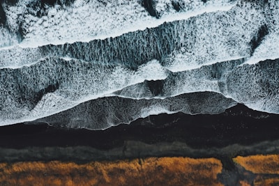 an aerial view of a beach with waves crashing on it