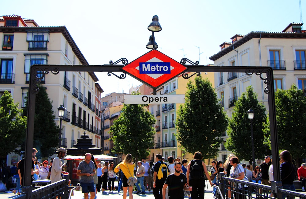 people standing under Metro Opera signage during daytime