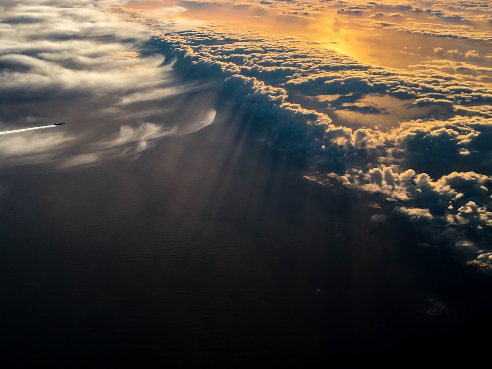 the sun shining through the clouds over the ocean