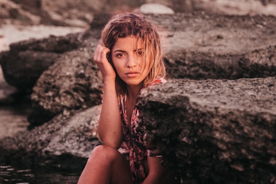 woman sitting on black rock formation in Batroun Lebanon