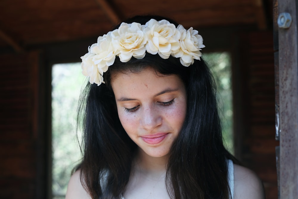 woman in white spaghetti strap top with white floral headband