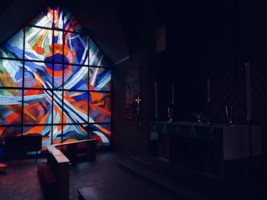 a large stained glass window in a dark room