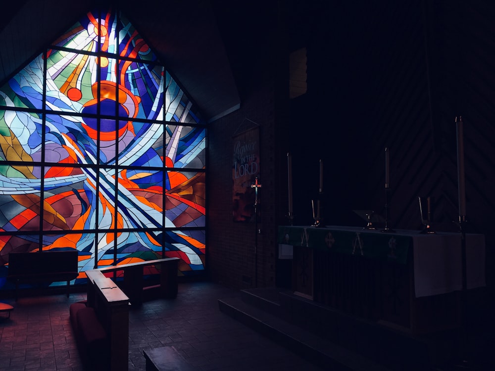 a large stained glass window in a dark room