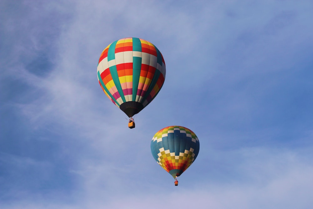 two multicolored hot air balloons floating on air