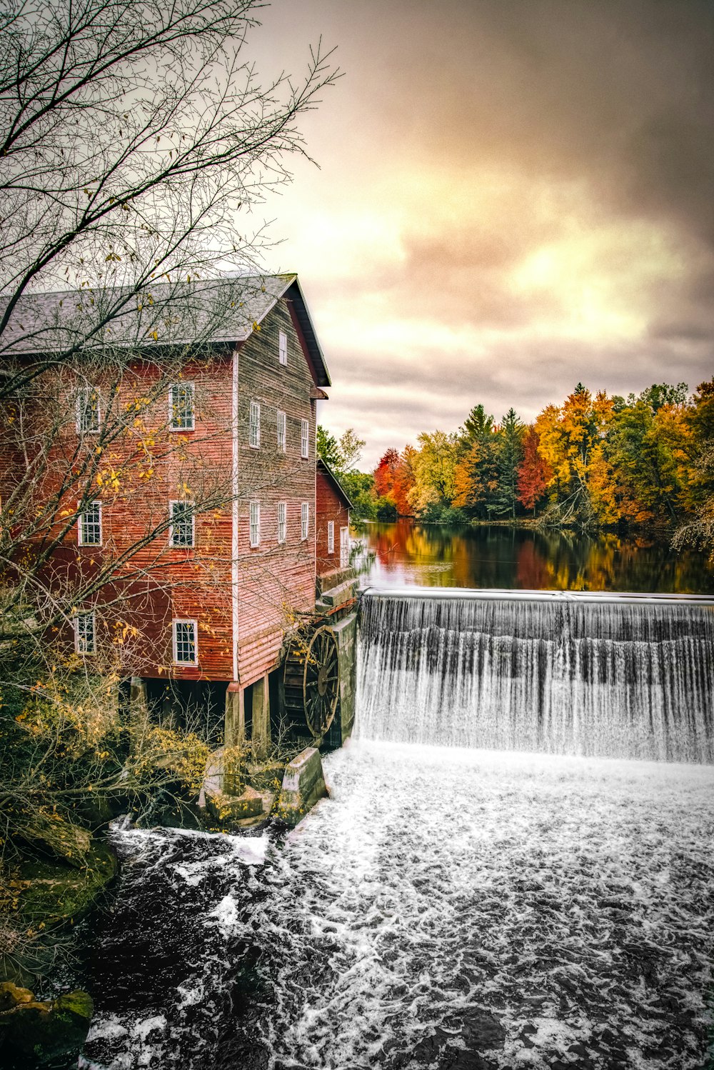 Wassermühle in der Nähe des Wasserfalls an bewölktem Tag