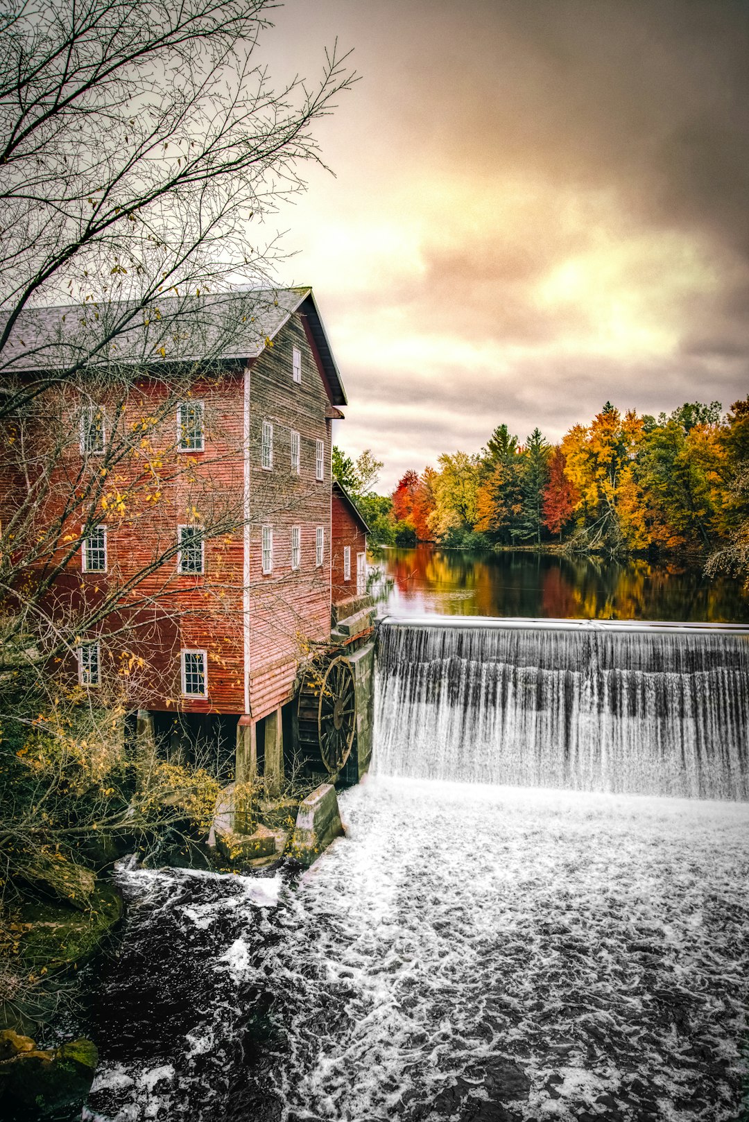 watermill near waterfall during cloudy day