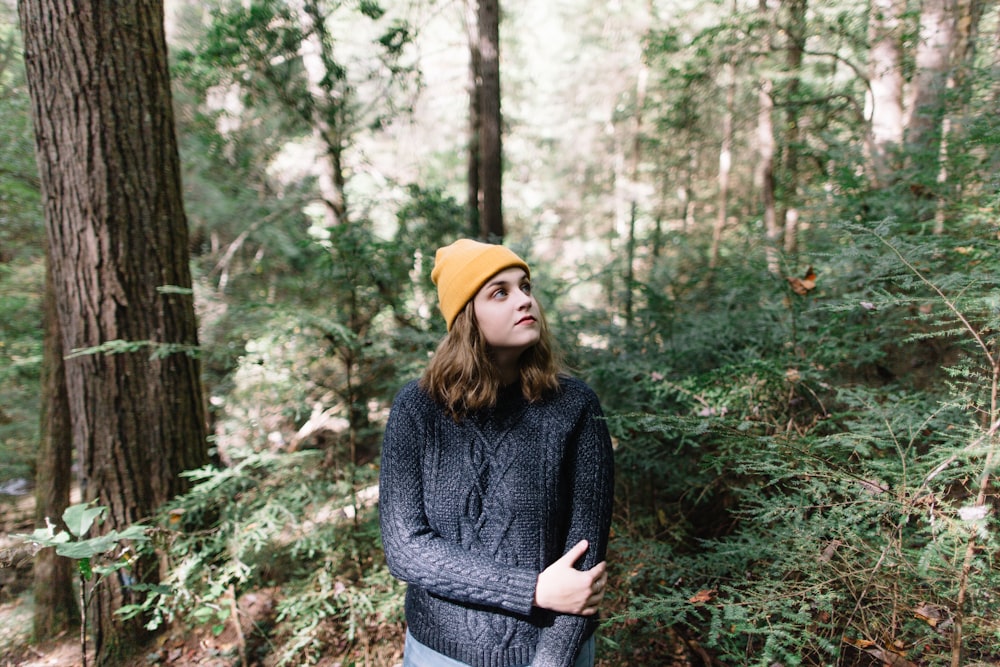 selective focus photography of woman standing in woods