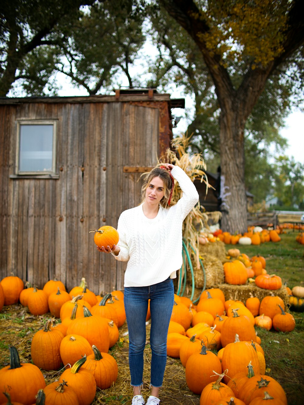 woman carrying orange pumpkin