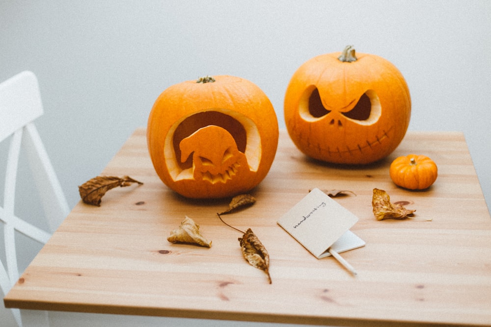 two orange pumpkins on brown wooden table