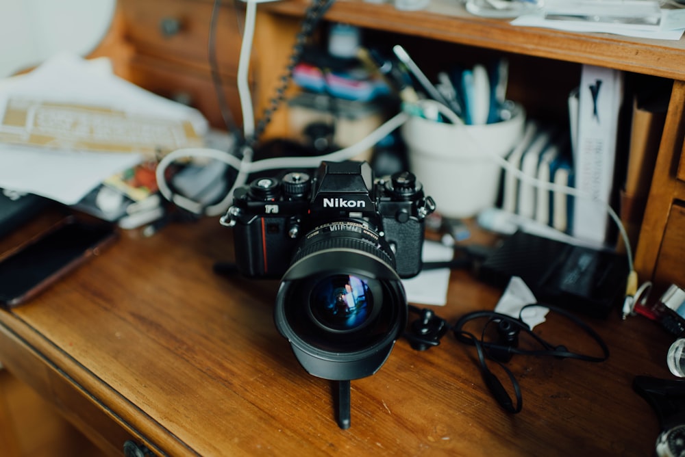 black Nikon camera on brown surface