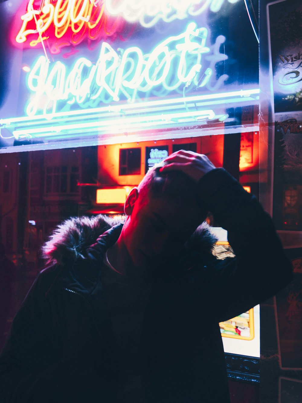 man standing near neon signs