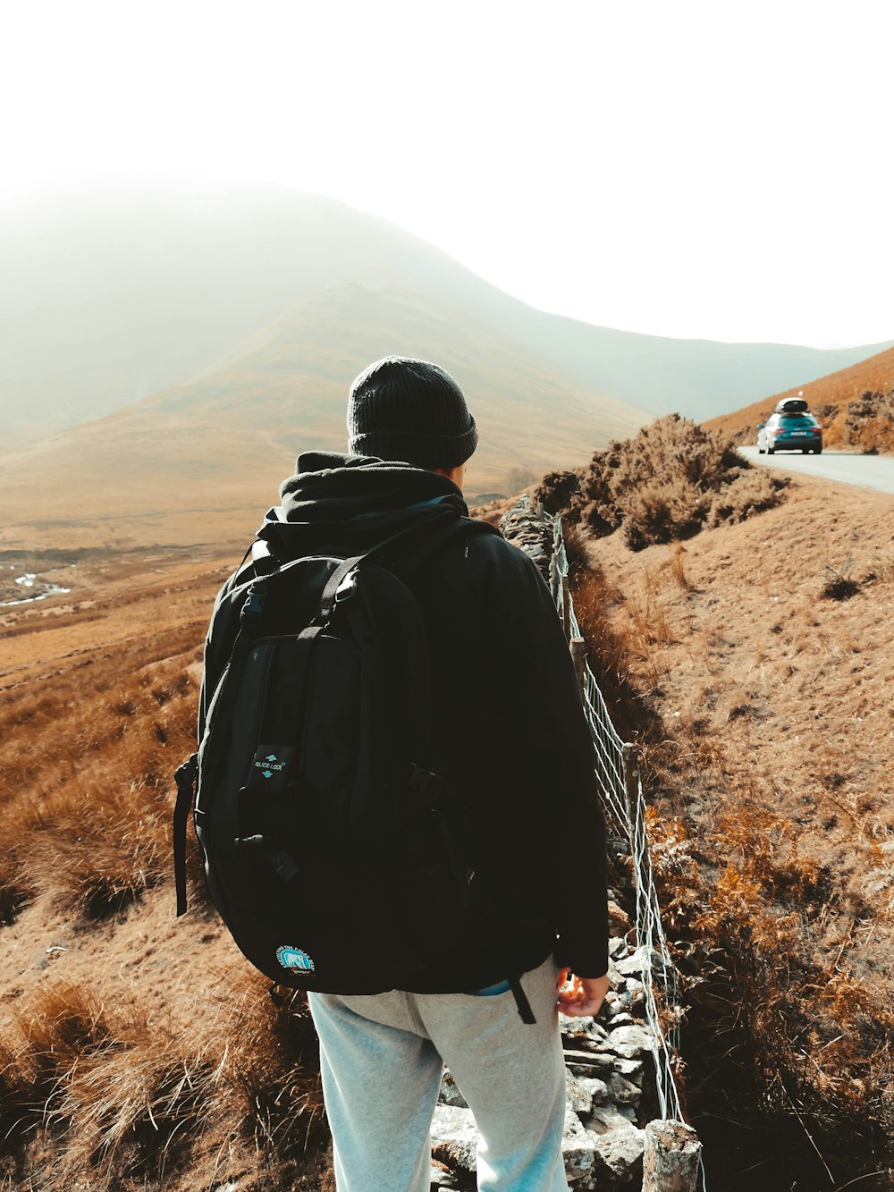 man in hoodie and backpack walking on stairs