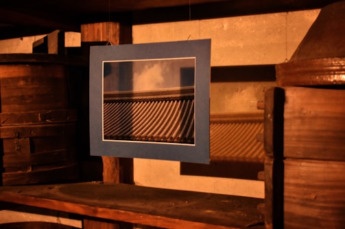 A high-quality photo of a framed physical print hanging on a cozy wall.