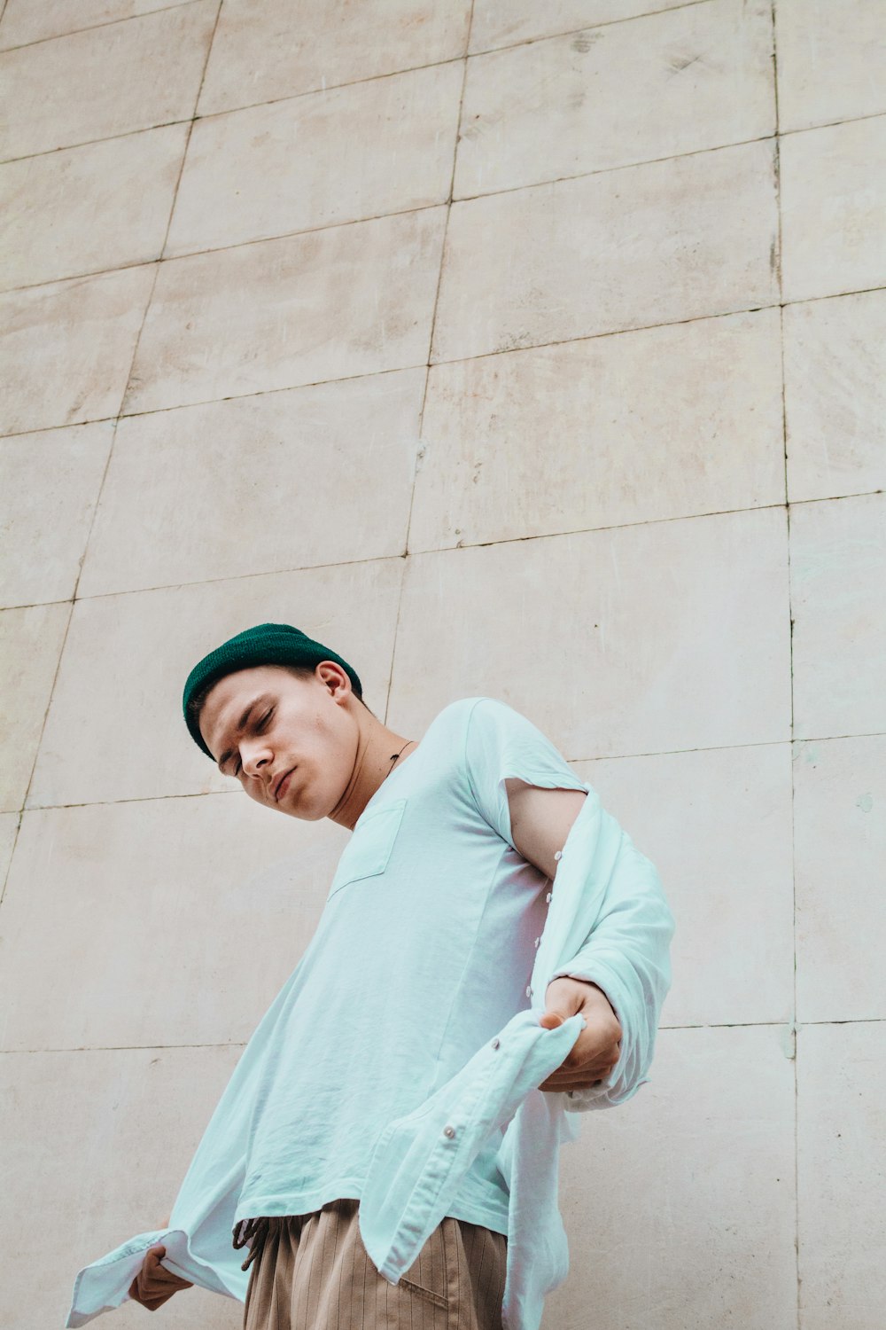 man standing beside concrete wall