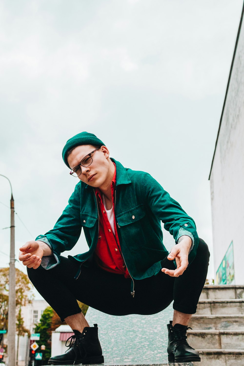 man wearing green jacket near brown stair