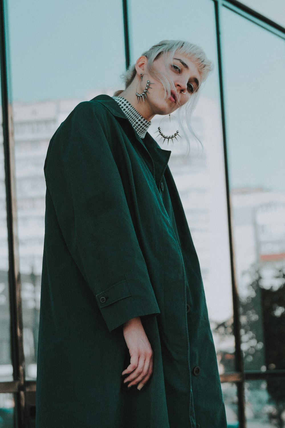 woman wearing black coat standing near clear glass wall