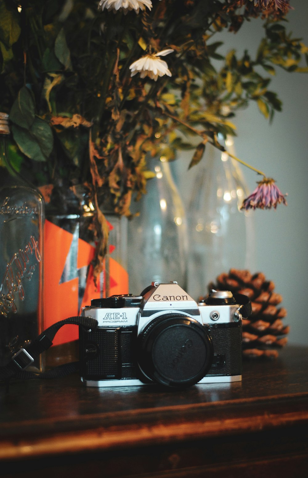 shallow focus photo of black and gray Canon SLR camera on brown wooden table