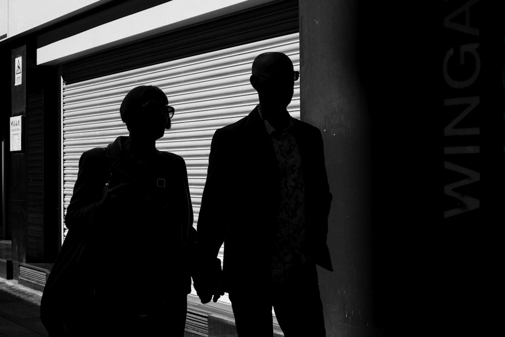 silhouette of man and woman walking inside building