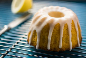 Close-up of a mini lemon loaf wrapped in parchment with a soft pink background