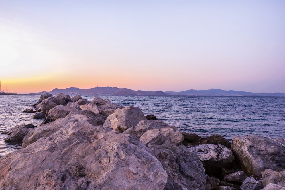 a large body of water sitting next to a rocky shore