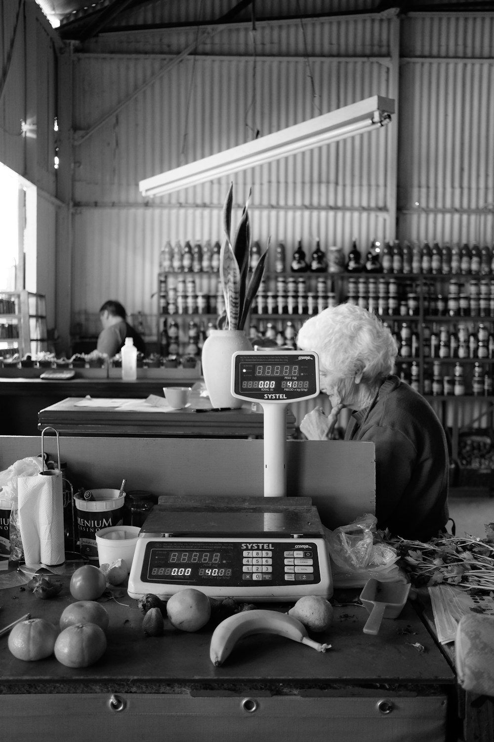 grayscale photography of woman near weighing scale