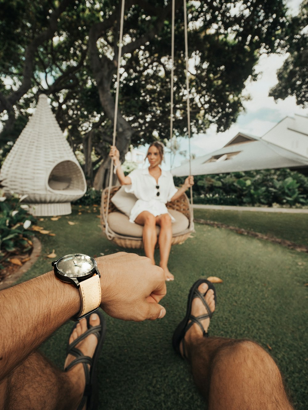 man sitting in front of a woman sitting on hanging chair