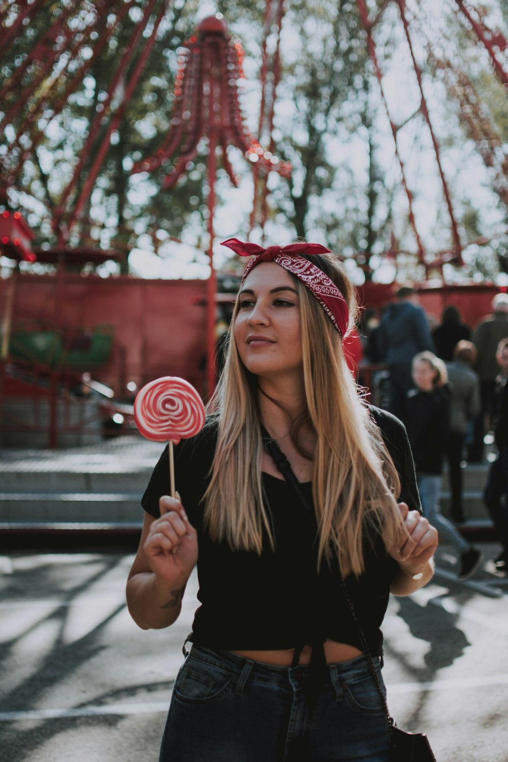 woman standing while holding red and white lollipop