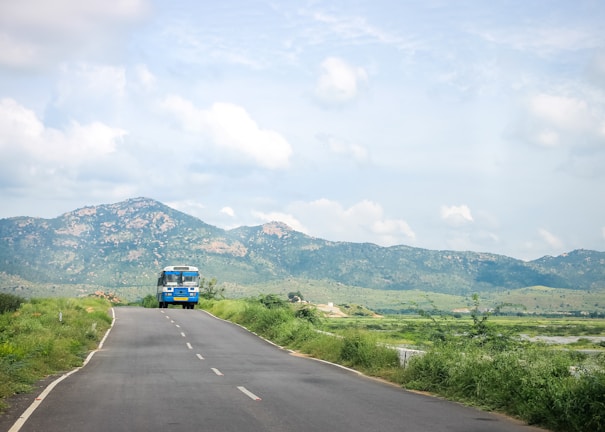 A scenic view of a bus traveling through lush green hills.