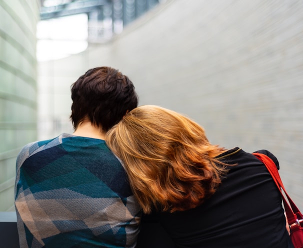 a woman rests her head on another person's shoulder