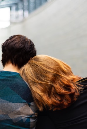 a woman rests her head on another person's shoulder