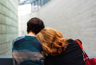 a woman rests her head on another person's shoulder