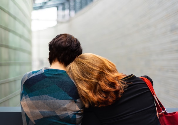 a woman rests her head on another person's shoulder