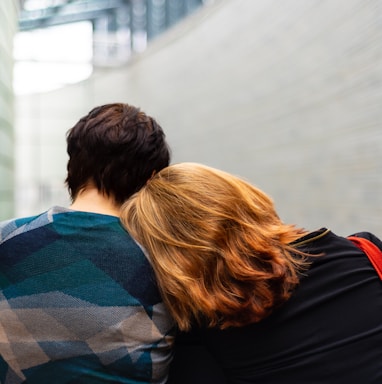 a woman rests her head on another person's shoulder