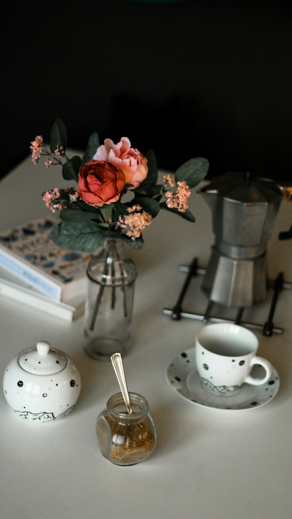 teacup by kettle and vase all on table top