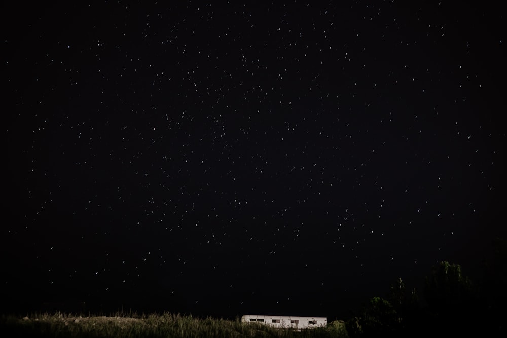 a house sitting in the middle of a field at night