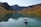 man riding on kayak surrounded by mountains