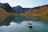 man riding on kayak surrounded by mountains