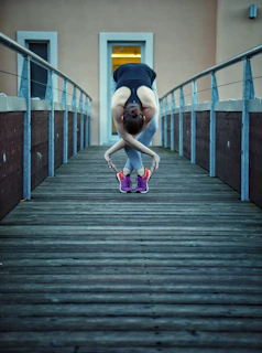 Athlete stretching outdoors at dawn, dressed in black and neon green Pulseforge activewear.