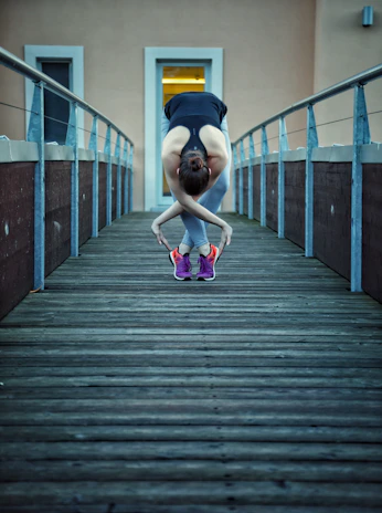 Athlete stretching outdoors at dawn, dressed in black and neon green Pulseforge activewear.