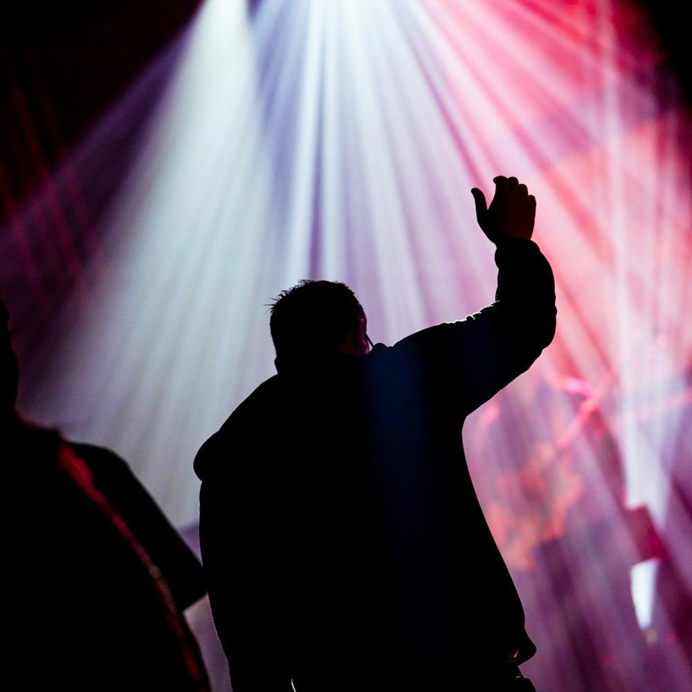 silhouette of man raising his right hand