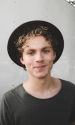 man standing near white wall