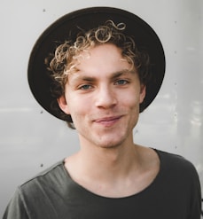 man standing near white wall