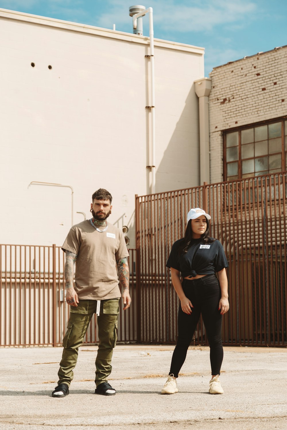 man and woman standing on front of brown building