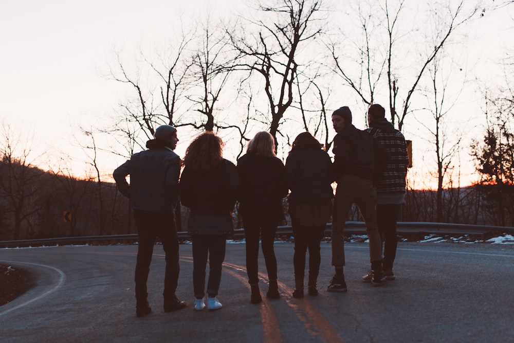 silhouette photography of six people standing on road