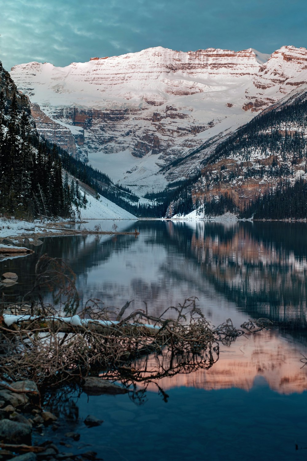 Fotografía panorámica de una montaña cubierta de nieve cerca del lago durante el día