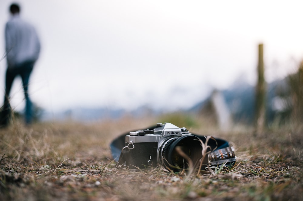 fotocamera Nikon nera e grigia a terra