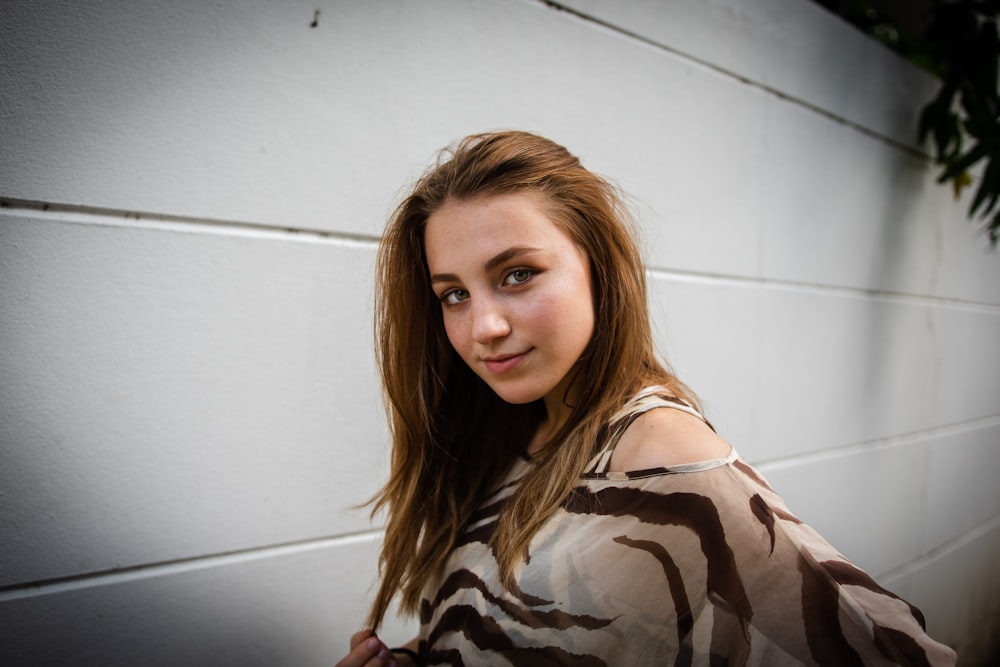 woman standing and posing near white wall