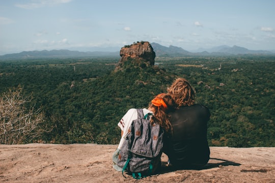 man and woman sitting beside cliff in Pidurangala Rock Sri Lanka